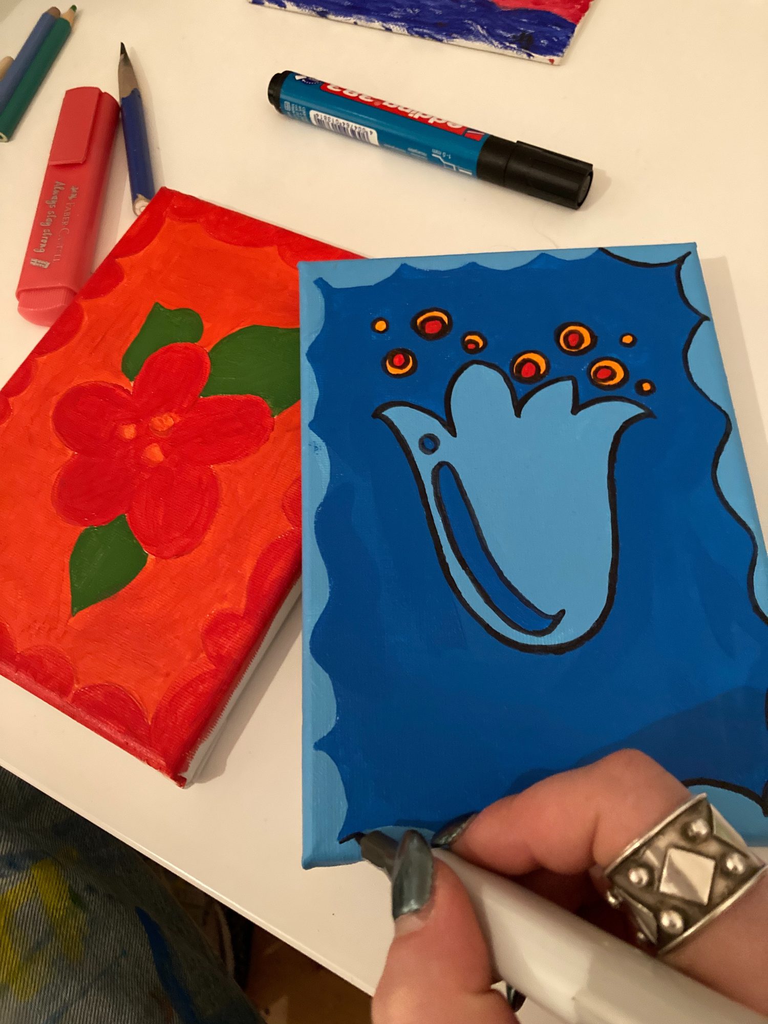 Painting a small blue canvas in the studio